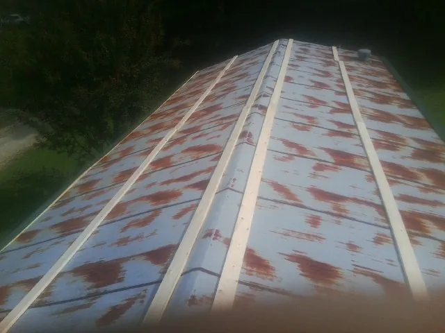 Rusted metal roof panels with new wood purlins before replacement — Storm Damage Roof Repair in Millers Creek by Roofing Brothers